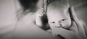 Baby schaut der Mutter über die Schulter.